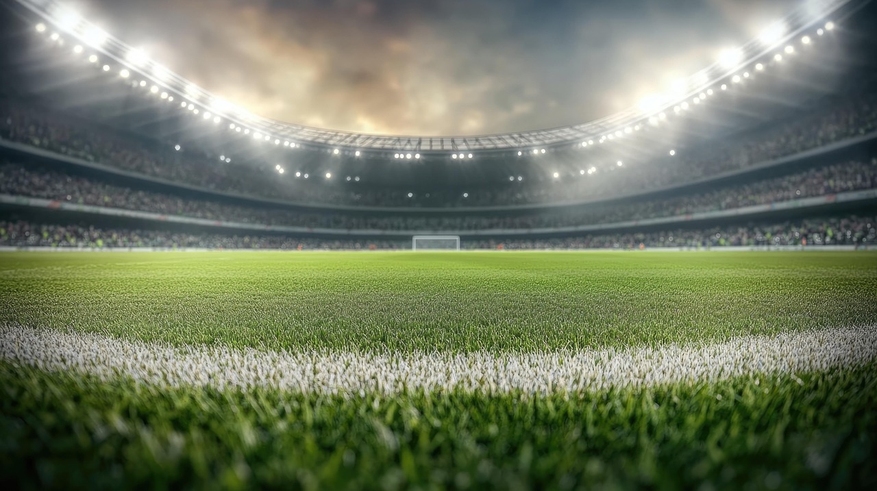 de foto laat een groot, voetbal stadion zien. vol met toeschouwers. in de verte is een doel te zien, er is een bewolkte avondlucht.