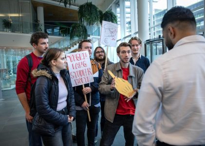 SP jongeren overhandigt ‘gouden middelvinger’ aan minister van onderwijs Eppo Bruijns.