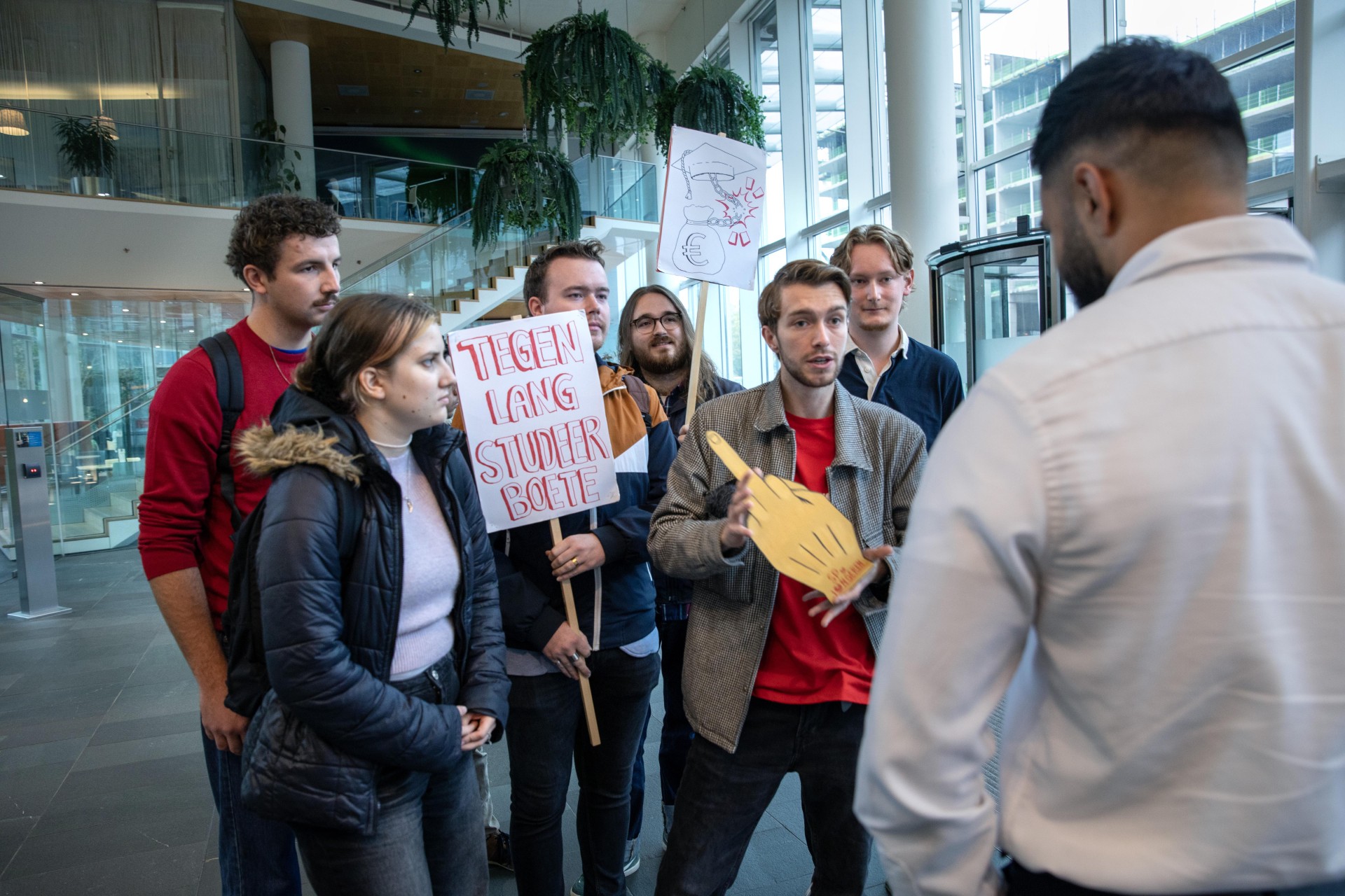 SP jongeren overhandigt ‘gouden middelvinger’ aan minister van onderwijs Eppo Bruijns.